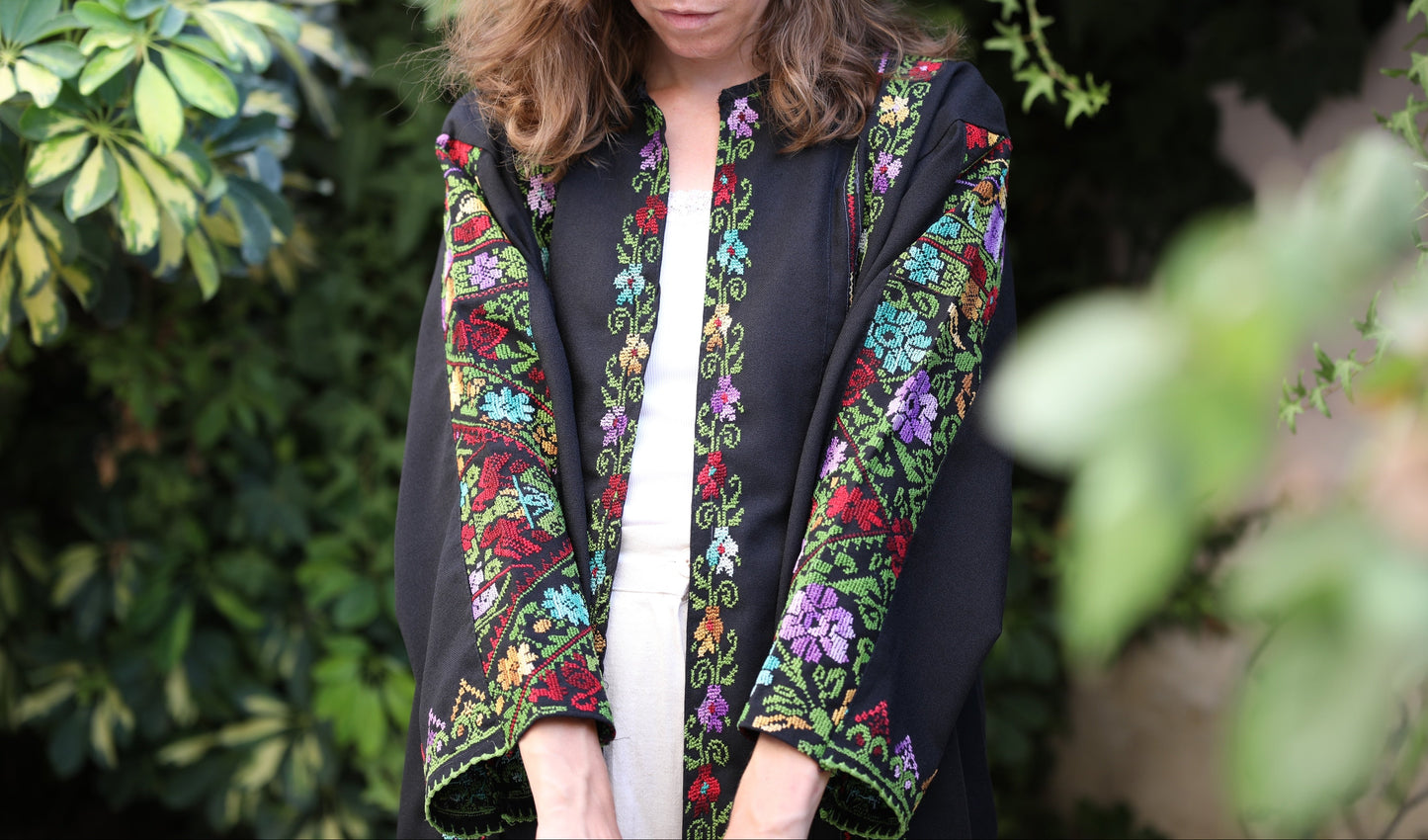 Woman wearing a black blazer with colorful Palestinian floral embroidery