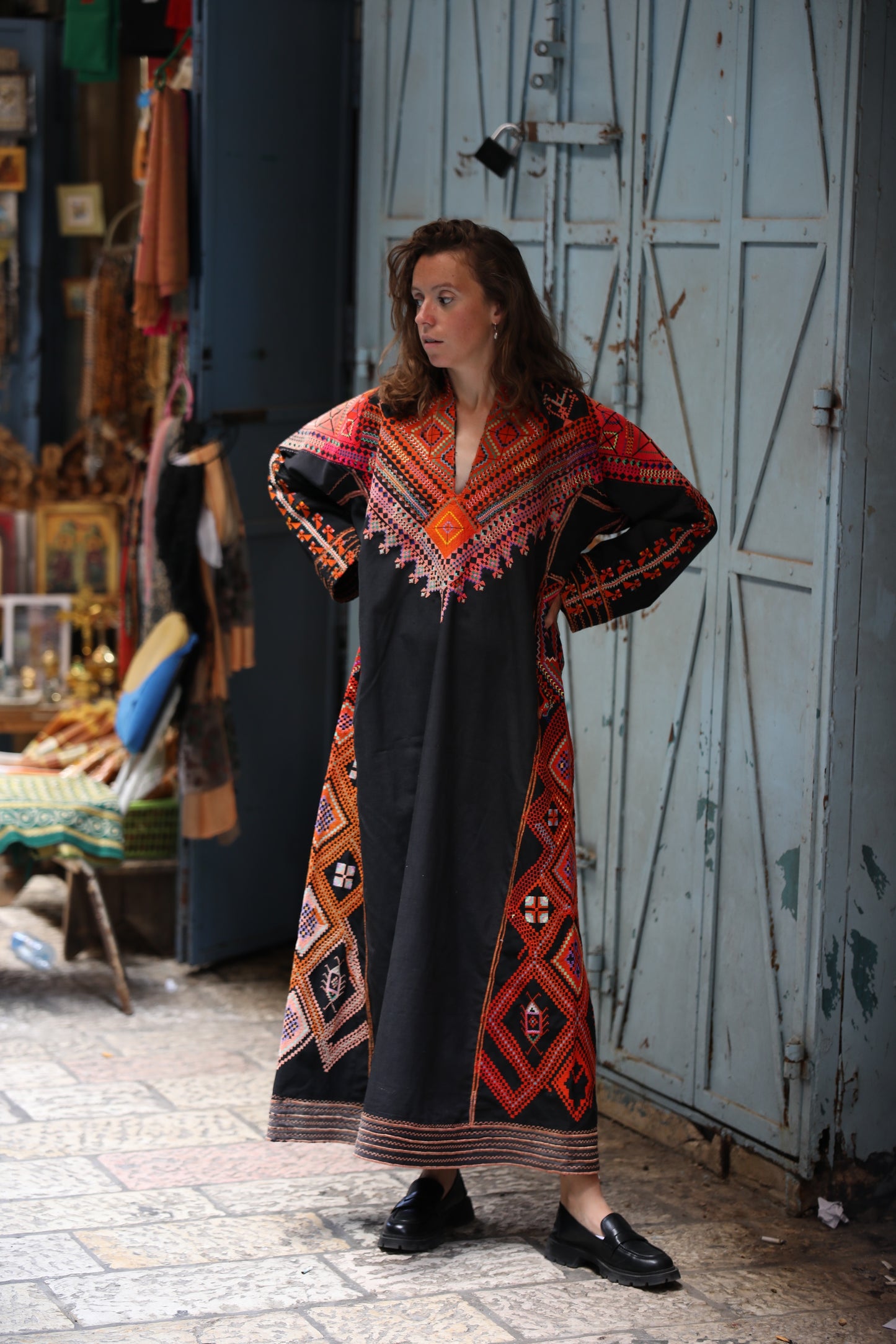 Woman wearing a colorful dress with geometric patterns in an outdoor setting.