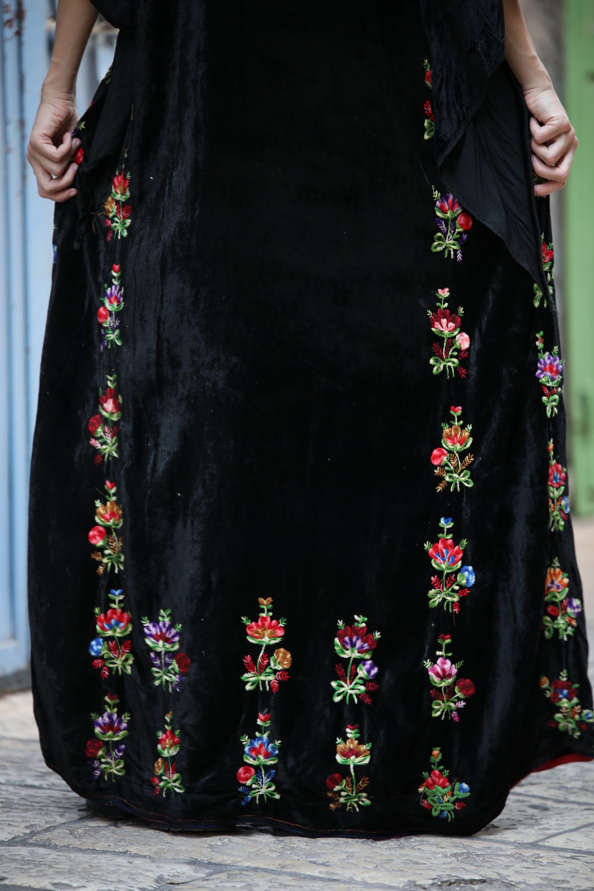 Black dress with colorful floral embroidery on a textured surface