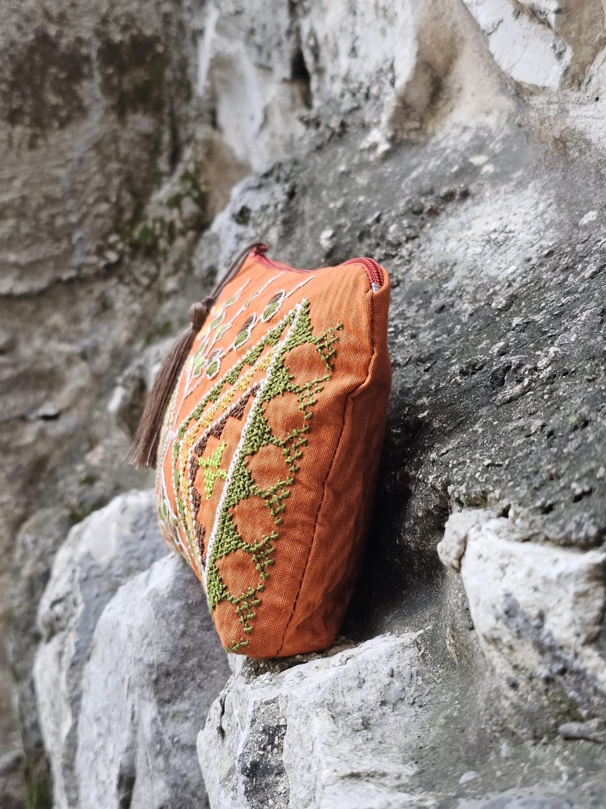 Decorative purse with intricate patterns on a rocky surface