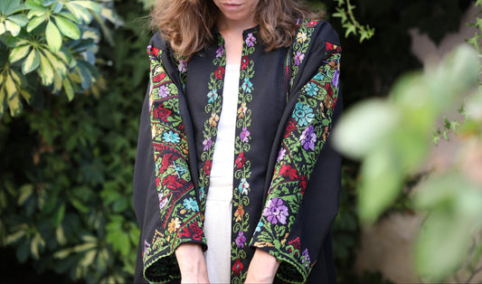 Woman wearing a black blazer with colorful Palestinian floral embroidery 