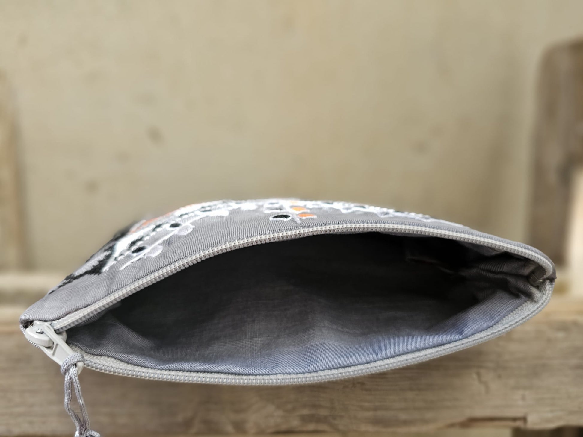 Gray pouch with a zipper on a wooden surface