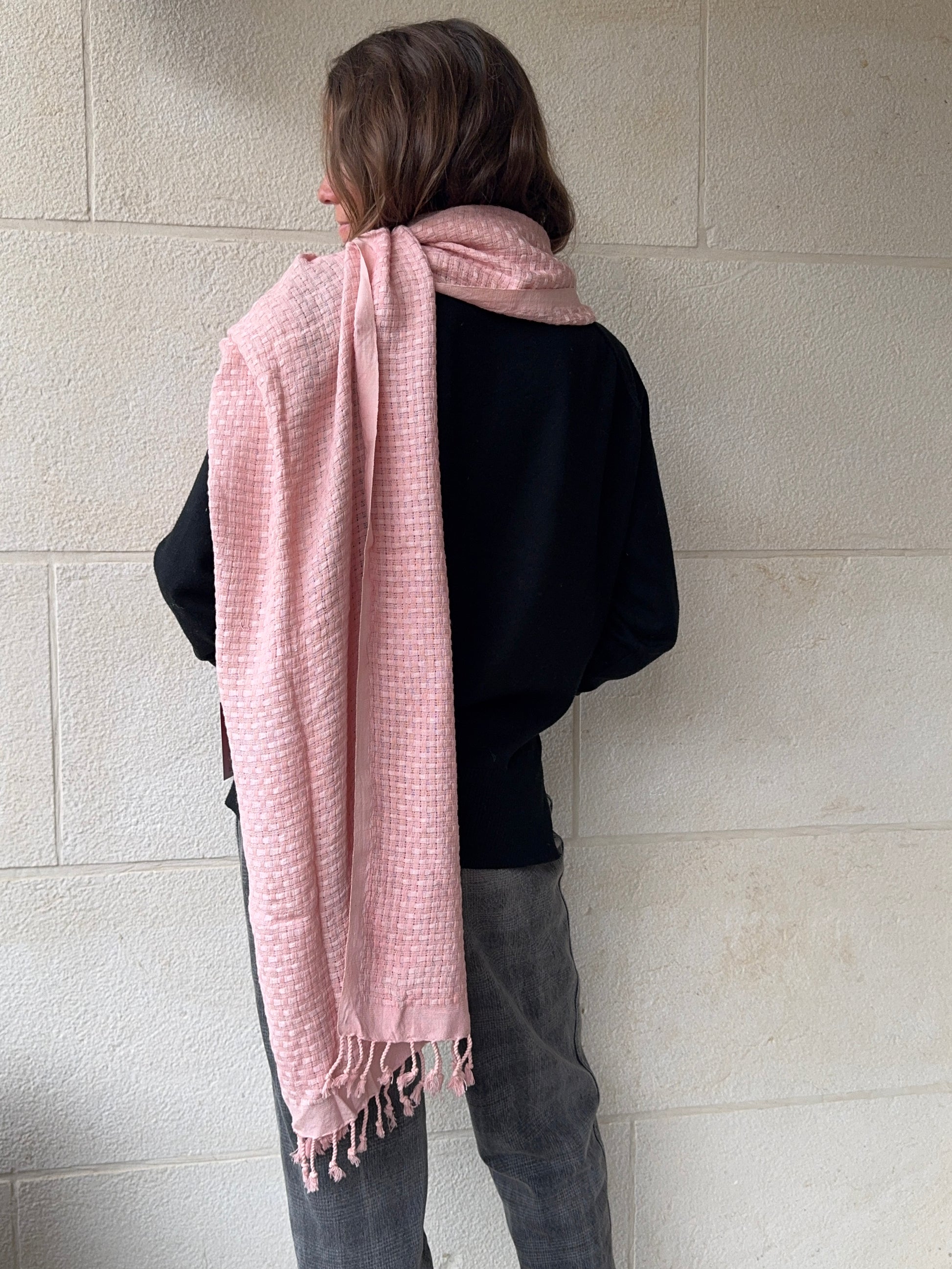 Person wearing a pink checkered scarf on a tiled floor