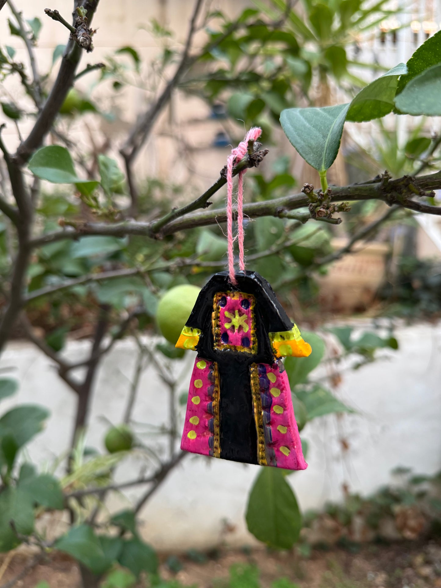 Colorful toy airplane attached to a tree branch with leaves in the background