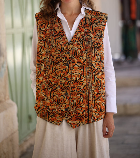 Woman wearing a patterned vest over a white shirt in an outdoor setting